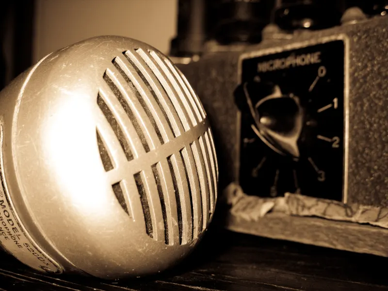 A vintage bullet microphone beside an amplifier volume knob