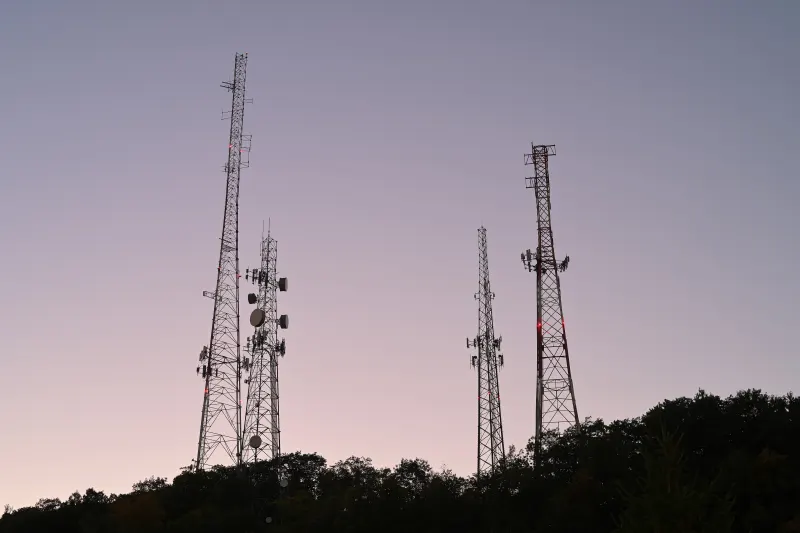 Radio transmitter towers silhouetted against the dusk sky
